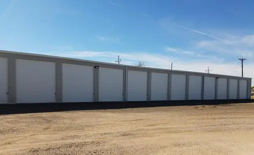 A large white building sitting in the middle of a field.